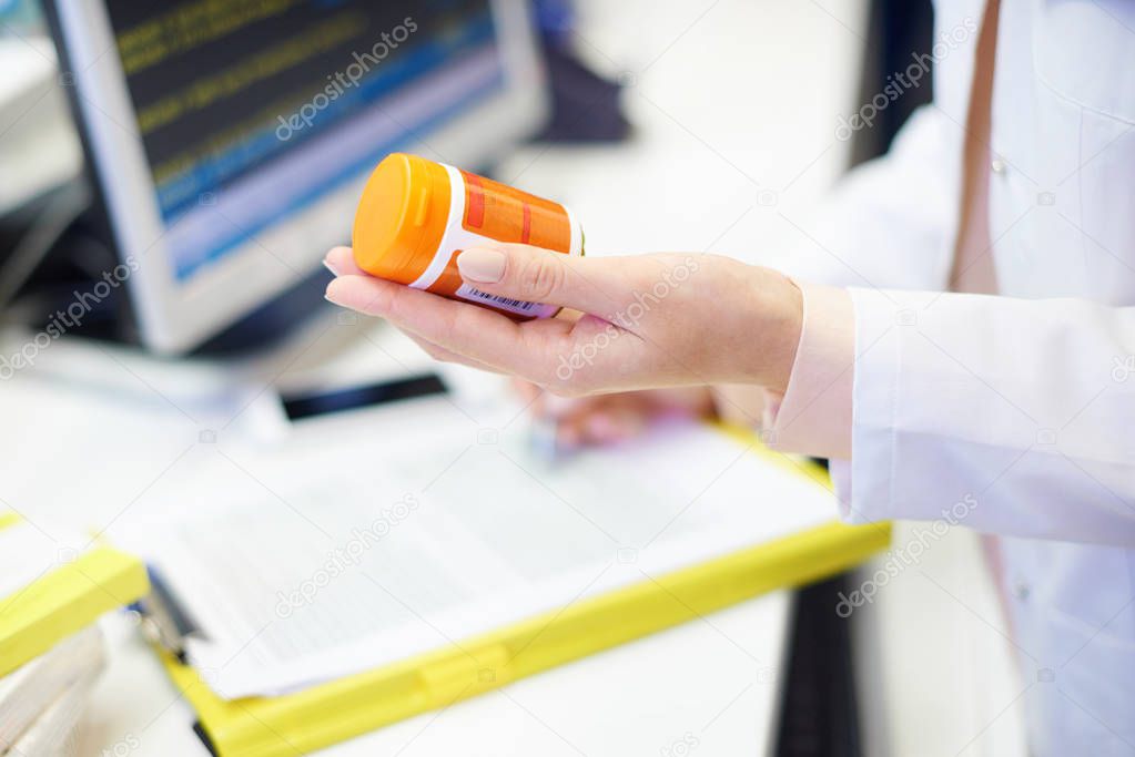 Pharmacist holding pill bottle