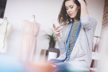 Cep telefonu kullaranarak kadın terzi 