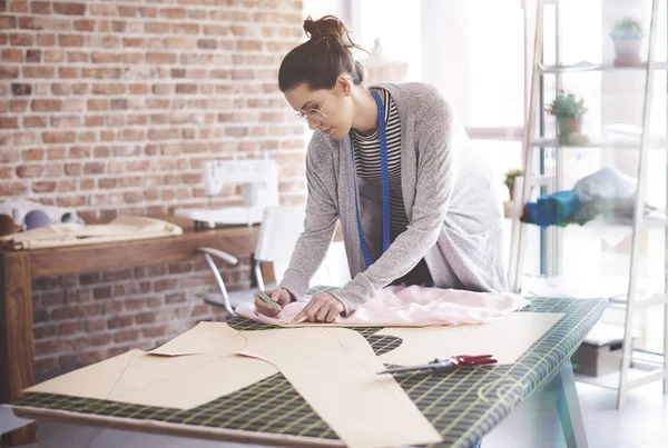 Jonge naaister chalking patronen tijdens haar workshop — Stockfoto