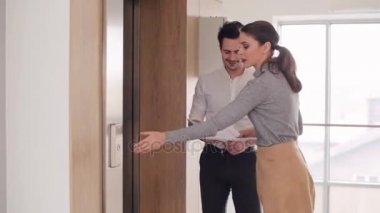 Asansörün yanında konuşurken iş ortakları 