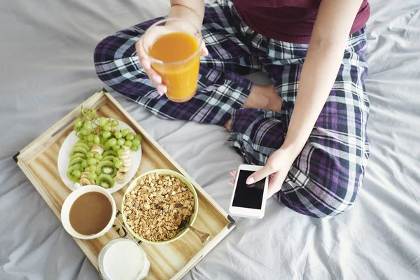 Femme prenant le petit déjeuner au lit — Photo