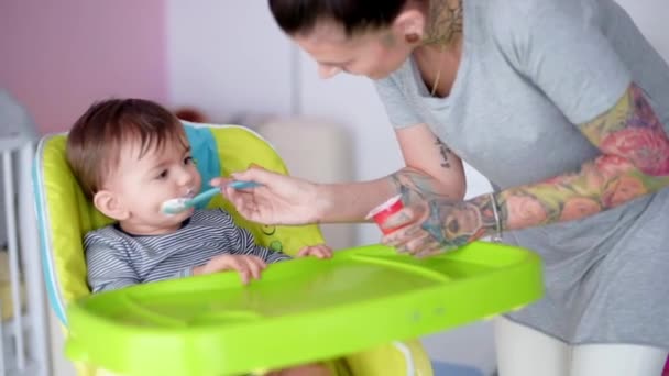 Мати годує дитину хлопчиком — стокове відео