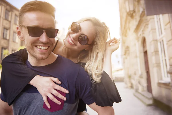 Uomo giocoso che porta la ragazza sulla schiena — Foto Stock