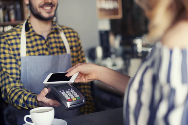 Cliente femenino pagando con tarjeta de crédito por taza de café —  Fotos de Stock