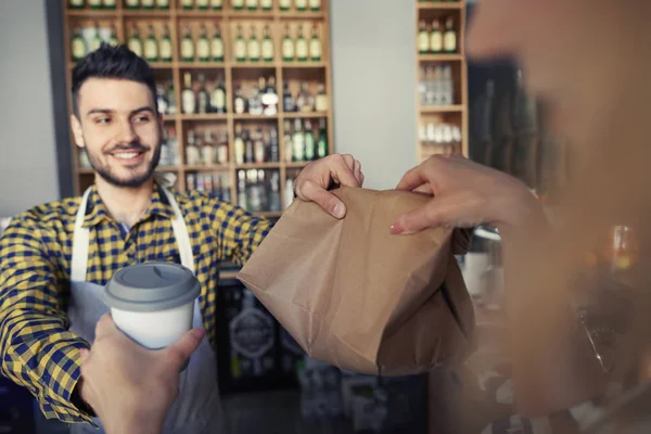 Barista περνώντας καφέ και ρολά στον υπολογιστή-πελάτη — Φωτογραφία Αρχείου