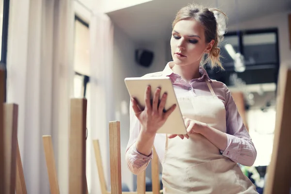 Serveerster in bar kijken naar orders in touchpad — Stockfoto