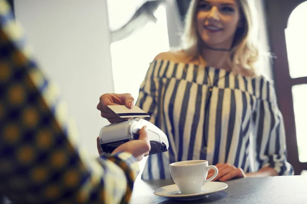Вид сверху на женщину, платящую за чашку кофе — стоковое фото