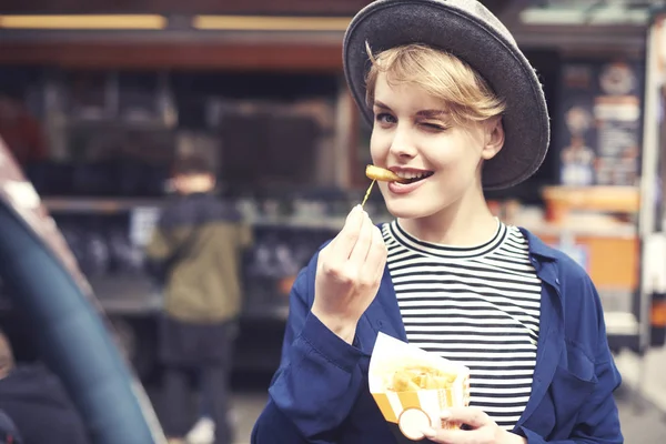 Porträtt av ung kvinna med frites winking — Stockfoto