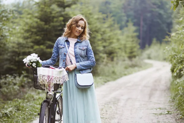 Femme à pied avec vélo — Photo