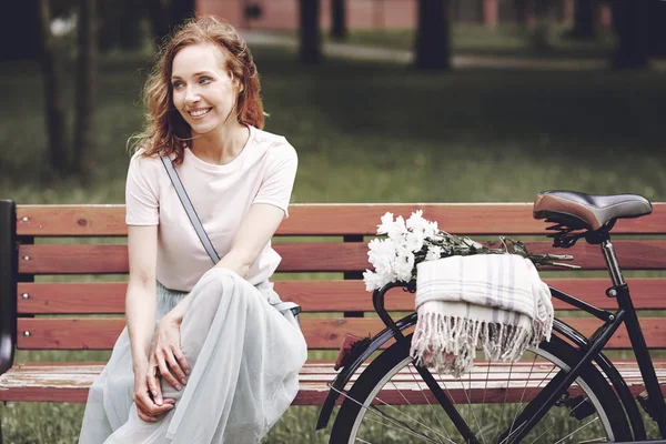 Woman sitting on wooden bench — Stock Photo, Image