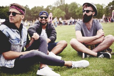 Bir konser başlamadan önce çimlerde oturan adam 