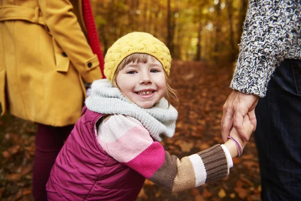 Sorridente menina segurando as mãos dos pais — Fotografia de Stock