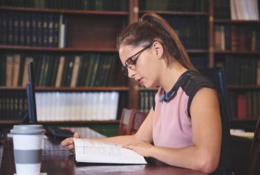 Kitaplığı'nda okuyan öğrenci kız