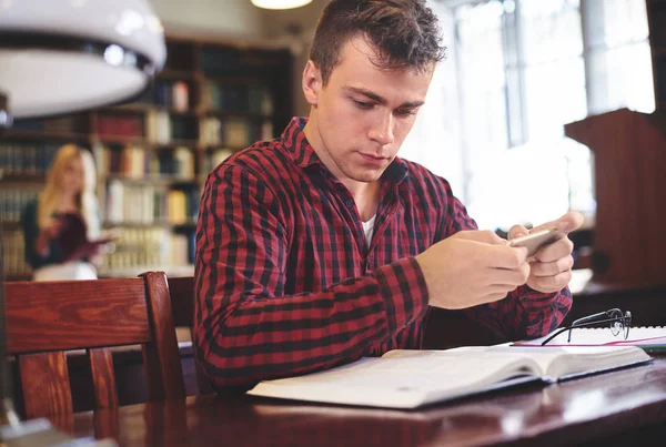 Mannelijke student studeert aan de bibliotheek — Stockfoto