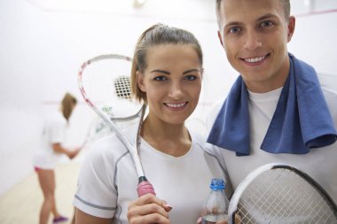 adam ve squash raketleri tutan kadın