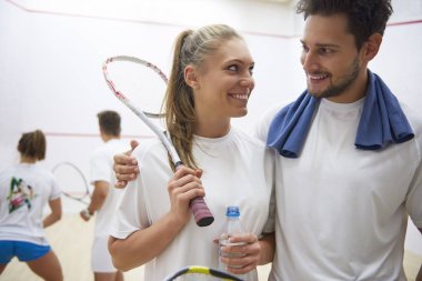 adam ve squash raketleri tutan kadın