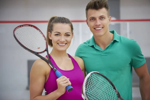 Homem e mulher segurando raquetes de squash — Fotografia de Stock