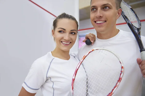 Homem e mulher segurando raquetes de squash — Fotografia de Stock