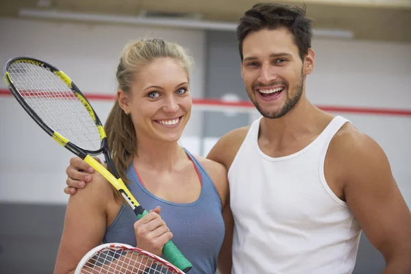 Man och kvinna som håller squash racketar — Stockfoto