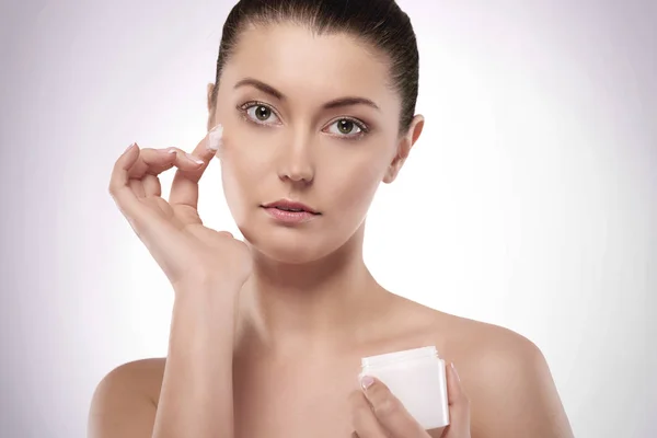 Woman applying cream — Stock Photo, Image