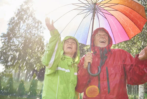 Äldre par leker med regn — Stockfoto