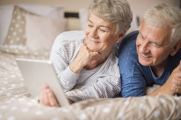Старший мужчина и женщина с помощью планшета ПК — стоковое фото