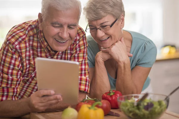 Senior couple looking for recipe — Stock Photo, Image