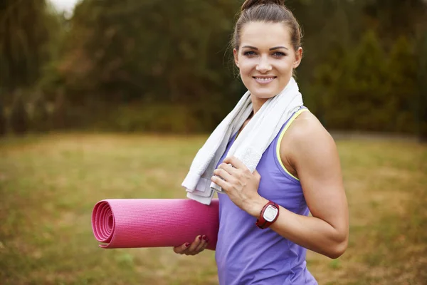 Donna che tiene tappetino yoga — Foto Stock