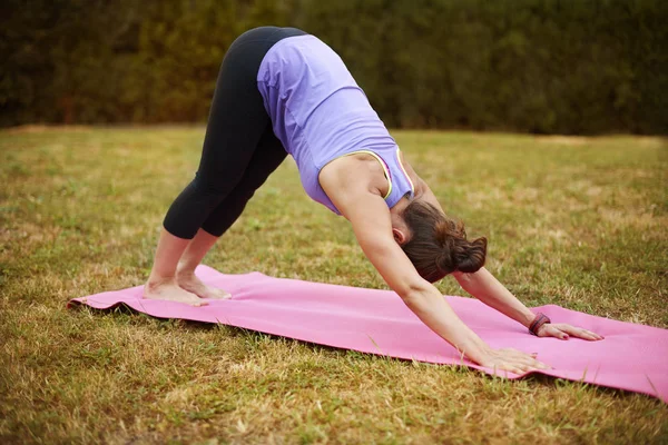 Kadın dışarıda yoga yapıyor. — Stok fotoğraf