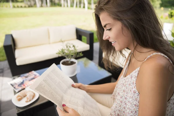 Vrouw reding krant — Stockfoto