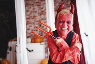 Boy in devil costume grimacing clipart