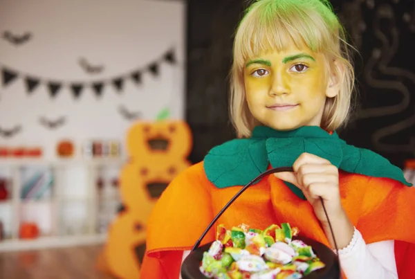 Dívka v kostýmu dýně s mísou cukroví — Stock fotografie