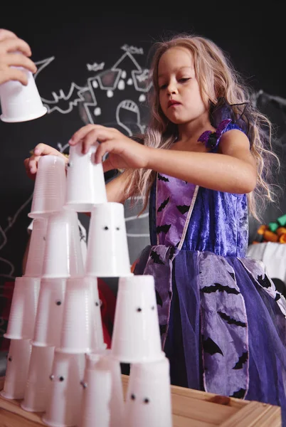 Tyttö noita puku järjestää pyramidi muovi kuppi — kuvapankkivalokuva