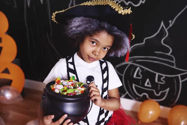 Dívka v kostýmu pirát drží misku bonbónů — Stock fotografie
