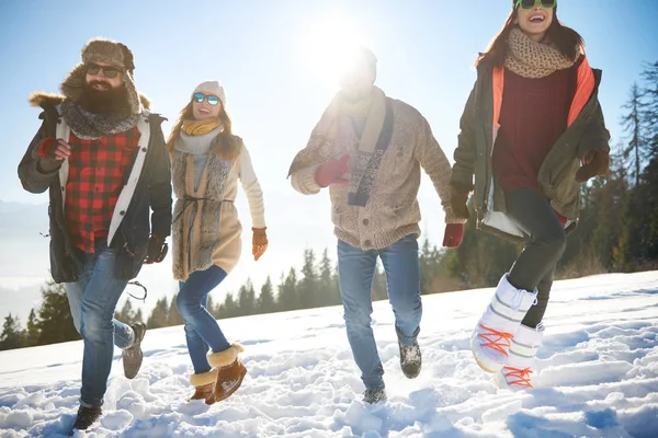 Friends running in the snow — Stock Photo, Image