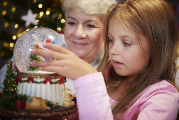 Senior met meisje met sneeuw bal — Stockfoto