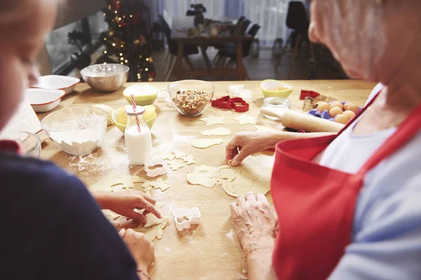 Tjej att göra kakor med mormor — Stockfoto
