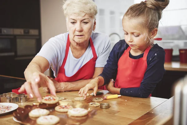 Grandmoother och barnbarn dekorera kakor — Stockfoto