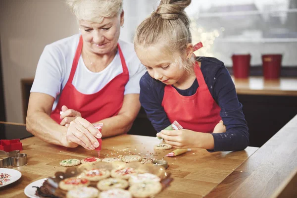 Nieto con abuela decorando galletas — Foto de Stock