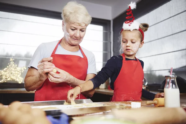 Chica poniendo galletas en bandeja para hornear — Foto de Stock