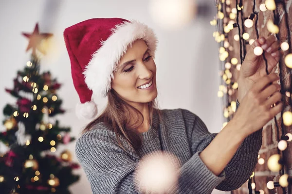 Mulher pendurado luzes de Natal — Fotografia de Stock