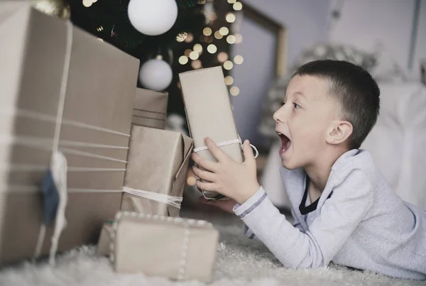 Pojken tittar på gåvor — Stockfoto