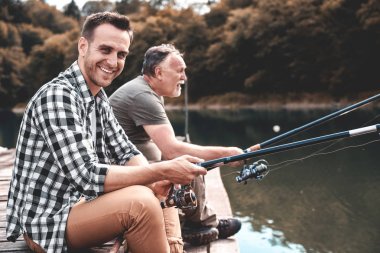 İki adam balık tutuyor.