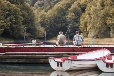 İki adam balık tutuyor.