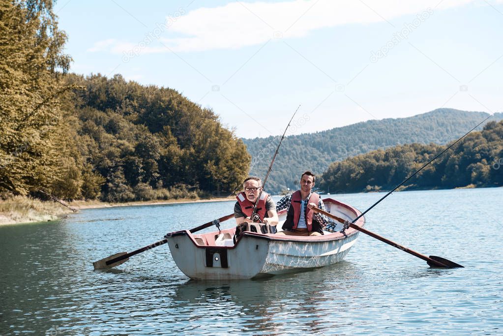  men fishing from rowboat 