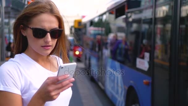 Vrouw texting bij busstation — Stockvideo