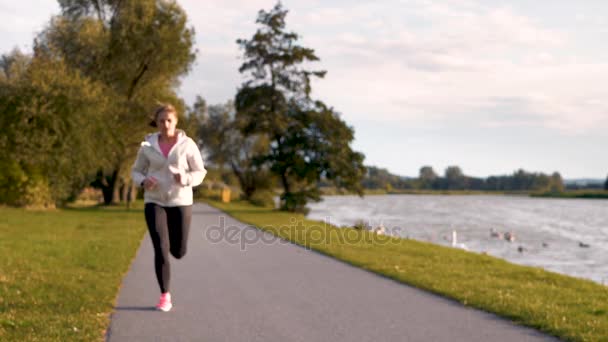 Női sportoló fut végig az út — Stock videók