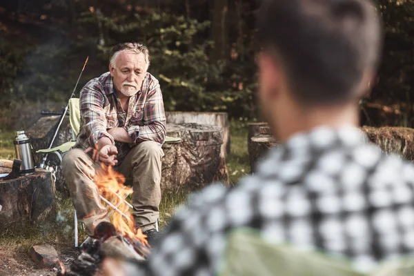 Mann sitzt am Lagerfeuer — Stockfoto