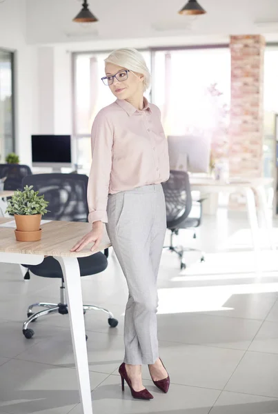 Geschäftsmann stützt sich auf Schreibtisch — Stockfoto