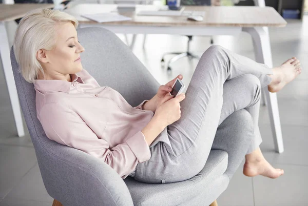 Mujer descalza con teléfono móvil relajante — Foto de Stock